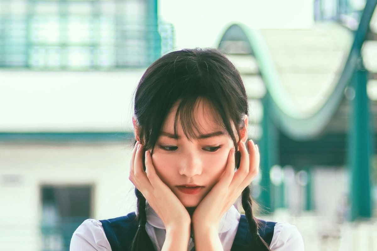 Thoughtful woman holding her face, illustrating the emotional struggle of social anxiety disorder and fear of social situations.