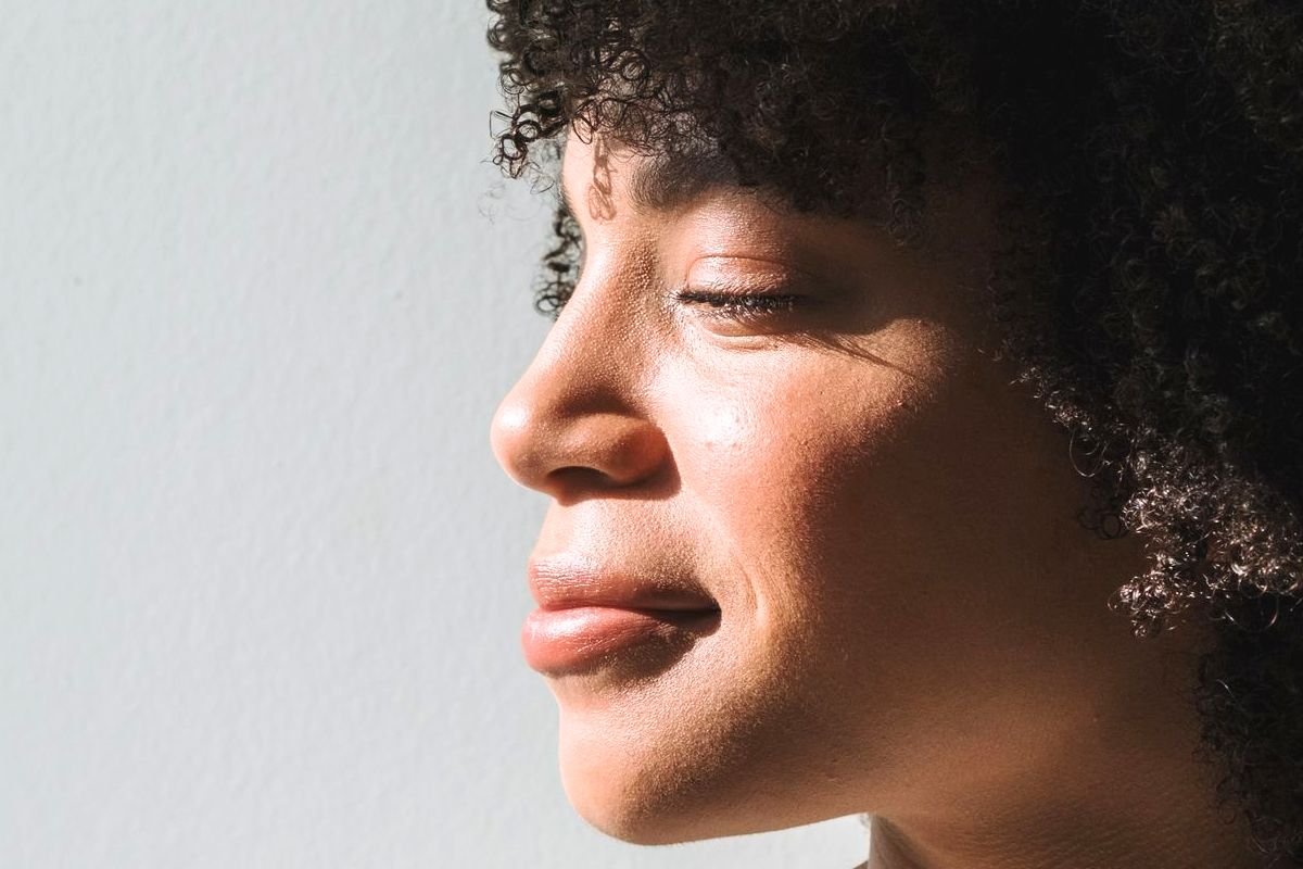 Woman smiling in sunlight while reflecting healthy ageing and bone health