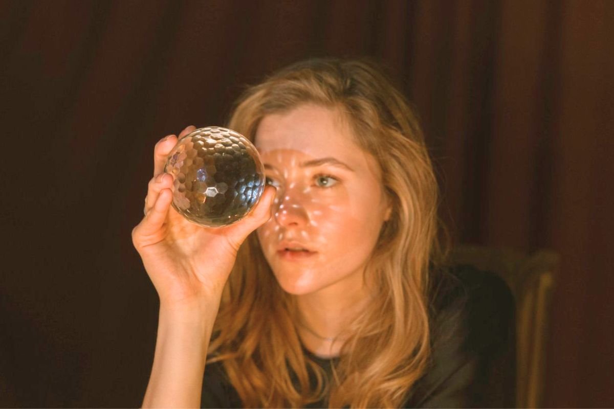 Woman looking into a crystal ball while imagining future possibilities