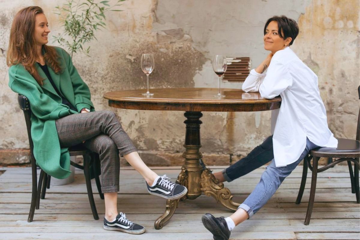 Two friends smiling and talking together at a table