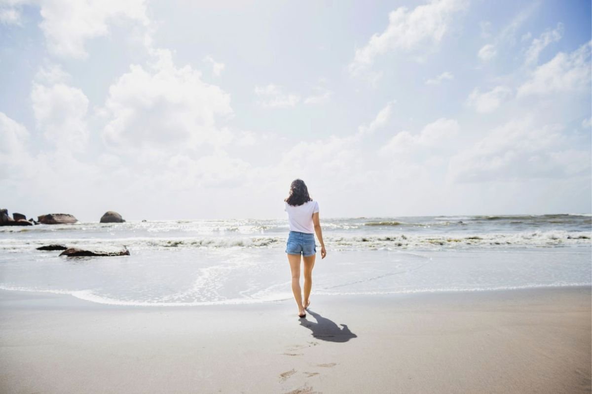 Woman walking alone beside the sea